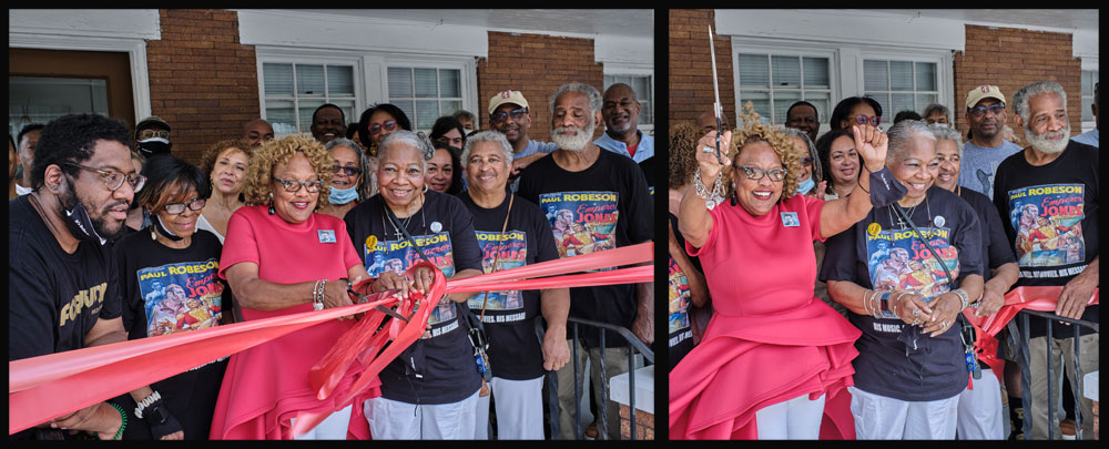 WPCA Executive Director Janice Sykes-Ross (center) cuts the ribbon for the reopening of the Paul Robeson House & Museum after a yearlong hiatus. Former Executive Director Vernoca L. Michael (left of her) and Program Director Christopher R. Rogers (right) join visitors and supporters at the ceremony.
