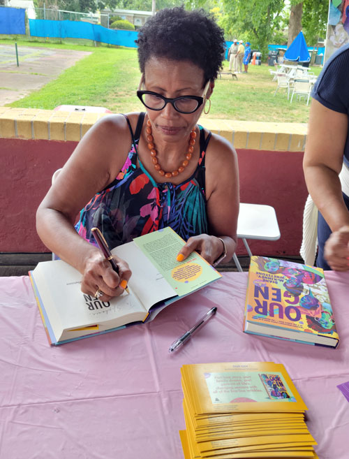Diane McKinney-Whetstone signs a book for a fan. Photo by Sherry L. Howard. 