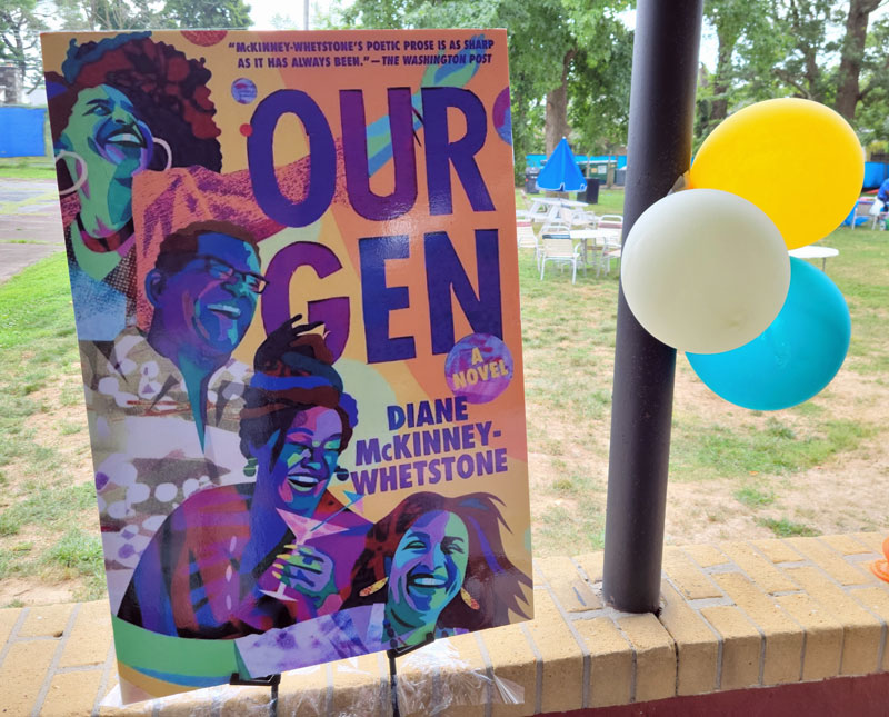 "Our Gen" poster in the form of the book cover. It shows a vibrant group of 60-something people full of laughter. Photo by Sherry L. Howard. 