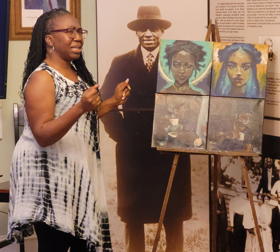 Artist Tanya Bracey with two of her smaller individual portraits. Photo by Sherry L. Howard.