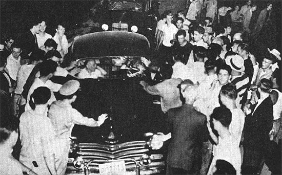 Mob surrounds car.
